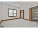 Spacious bedroom with window, ceiling fan, and closet featuring wood trim and light carpet at 936 Bo Bo Banks Rd, Grantville, GA 30220