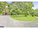Long concrete driveway leading to the house, surrounded by mature trees and green lawn at 936 Bo Bo Banks Rd, Grantville, GA 30220