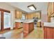 Bright kitchen with wood cabinetry, an island, stainless steel appliances, and hardwood floors at 936 Bo Bo Banks Rd, Grantville, GA 30220