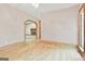 Open living room featuring hardwood floors and an arched doorway with a glimpse of a fireplace at 936 Bo Bo Banks Rd, Grantville, GA 30220