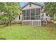 Back view of a house with a screened porch overlooking a green lawn and surrounding trees at 936 Bo Bo Banks Rd, Grantville, GA 30220