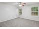 Carpeted bedroom features a ceiling fan, two windows, and light-colored walls at 1528 Wembley Dr, Douglasville, GA 30134