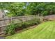 A well-maintained backyard with a lush lawn, mature trees, and a wooden fence for added privacy at 2864 Wyndcliff Ct, Marietta, GA 30066
