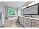 Bathroom featuring a soaking tub, double vanity, large framed mirror and natural light at 2864 Wyndcliff Ct, Marietta, GA 30066