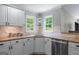 Corner kitchen area features granite countertops, white cabinets, and a stainless steel dishwasher at 2864 Wyndcliff Ct, Marietta, GA 30066