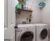 Functional laundry room with modern white washer and dryer and ample shelving space for storage at 2864 Wyndcliff Ct, Marietta, GA 30066