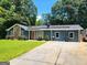 Property with solar panels, a stone accent, landscaped lawn, and a long driveway at 2913 Jordan Forest Trail, Lawrenceville, GA 30044