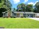 Charming home featuring a stone accent wall, well-maintained lawn, and blooming flowerbeds at 2913 Jordan Forest Trail, Lawrenceville, GA 30044