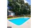 Inviting backyard pool surrounded by lush trees, ideal for cooling off on hot days with lounging furniture at 2913 Jordan Forest Trail, Lawrenceville, GA 30044
