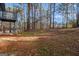 Expansive backyard featuring mature trees, open space, and a partial view of an elevated deck, perfect for outdoor activities at 4064 Chimney Ridge Way, Ellenwood, GA 30294