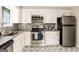 Bright kitchen with stainless steel appliances, granite countertops, and a stylish decorative tile floor at 4064 Chimney Ridge Way, Ellenwood, GA 30294