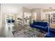 Open-concept living area with hardwood floors, blue velvet furniture, and a dining area nearby at 4064 Chimney Ridge Way, Ellenwood, GA 30294