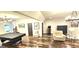 Well-lit game room boasts hardwood floors, a pool table, seating, and stylish decor at 4564 Investors Ln, Ellenwood, GA 30294
