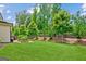 Lush green backyard showcasing mature trees, a garden bed and level lawn space at 4972 Park Vale Dr, Sugar Hill, GA 30518