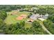 High aerial view showing ball fields, tennis courts, a pavilion, and parking nestled among lush greenery in the community at 4972 Park Vale Dr, Sugar Hill, GA 30518