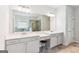 Bright bathroom featuring double sinks, white cabinets, and a large mirror at 4972 Park Vale Dr, Sugar Hill, GA 30518