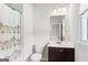 Bright bathroom featuring a dark vanity with a white sink, shower with unique curtain at 4972 Park Vale Dr, Sugar Hill, GA 30518