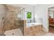 Contemporary bathroom with a tiled walk-in shower and soaking tub with a window at 4972 Park Vale Dr, Sugar Hill, GA 30518