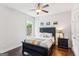 Cozy bedroom with a dark wood floor, ceiling fan, and large window view at 4972 Park Vale Dr, Sugar Hill, GA 30518