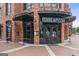 The exterior view of Shine Pizza in a brick building with dark trim, an awning, and outdoor seating at 4972 Park Vale Dr, Sugar Hill, GA 30518