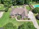 Aerial view of a brick home featuring a well-manicured lawn, mature trees, and tasteful landscaping at 186 Ashley Dr, Mcdonough, GA 30252