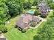 Aerial view of a brick home with mature trees, landscaping, fenced yard, and in-ground pool at 186 Ashley Dr, Mcdonough, GA 30252