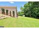 An expansive green backyard with a wood fence and a brick house with wooden stairs to the deck at 186 Ashley Dr, Mcdonough, GA 30252