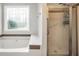 A bathroom boasts a soaker tub and a shower with a glass door, as well as a stained glass window at 186 Ashley Dr, Mcdonough, GA 30252