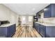 Open kitchen with blue cabinets, modern appliances, and laminate floors at 186 Ashley Dr, Mcdonough, GA 30252