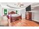 A primary bedroom features a hardwood floor, a ceiling fan, and a large bed with nightstands and a dresser at 186 Ashley Dr, Mcdonough, GA 30252
