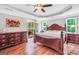 A primary bedroom features a screened door, a ceiling fan, and a large bed with nightstands and a dresser at 186 Ashley Dr, Mcdonough, GA 30252
