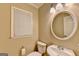 Powder room featuring a classic vanity with a round mirror and a window for natural light at 3034 Brookgreen Trl, Lawrenceville, GA 30043