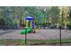 Community playground with colorful play structure in a fenced area surrounded by trees at 3034 Brookgreen Trl, Lawrenceville, GA 30043