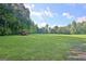 Large green field with scattered trees and a tractor in the distance at 5187 Lower Fayetteville Rd, Sharpsburg, GA 30277