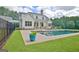 Beautiful backyard with a sparkling pool, lush lawn, and a charming white farmhouse-style home at 5187 Lower Fayetteville Rd, Sharpsburg, GA 30277