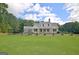Spacious backyard with a lush lawn, black fence, and elegant white home, ideal for outdoor entertaining and recreation at 5187 Lower Fayetteville Rd, Sharpsburg, GA 30277