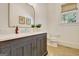 Charming bathroom featuring a classic vanity, a marble countertop, and natural light from a window at 5187 Lower Fayetteville Rd, Sharpsburg, GA 30277