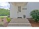 Front entrance with brick steps leading to a white front door featuring a welcome sign at 5187 Lower Fayetteville Rd, Sharpsburg, GA 30277