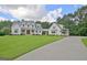 Stunning two-story farmhouse with a lush lawn, a long driveway, and attached garage at 5187 Lower Fayetteville Rd, Sharpsburg, GA 30277