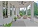 Relaxing covered porch with wicker seating, ceiling fan, and elegant decor, ideal for enjoying the outdoors at 5187 Lower Fayetteville Rd, Sharpsburg, GA 30277