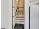 Stairway with black hexagonal tile landing and wood steps ascending to the upper level of the home at 5187 Lower Fayetteville Rd, Sharpsburg, GA 30277