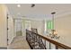 Hallway with wrought iron railing, chandelier, and multiple doorways, creating a spacious and well-lit transition area at 324 Chimney Sweep Cir, Peachtree City, GA 30269