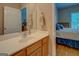 This bathroom has a mirror with wood cabinets, a white sink, and view of a bedroom at 1041 Flat Rock Rd, Covington, GA 30014