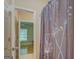 Bathroom featuring tile floors, shower with floral curtains, and bedroom doorway view at 1041 Flat Rock Rd, Covington, GA 30014