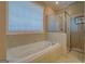Bathroom with a bathtub, shower, and tiled walls with a window at 1041 Flat Rock Rd, Covington, GA 30014