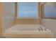 Bathroom featuring a large tiled bathtub with a window at 1041 Flat Rock Rd, Covington, GA 30014