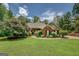 Attractive front exterior of a brick home with a lush green lawn, mature landscaping, and charming details at 1041 Flat Rock Rd, Covington, GA 30014