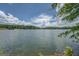Beautiful lake view presents peaceful water and lush trees under an open sky filled with fluffy white clouds at 1041 Flat Rock Rd, Covington, GA 30014