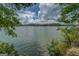 Tranquil lake view framed by lush trees with serene water, clear sky, and scattered clouds at 1041 Flat Rock Rd, Covington, GA 30014