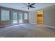 The living room has tan carpet, doors to outside, a ceiling fan and a closet at 1041 Flat Rock Rd, Covington, GA 30014